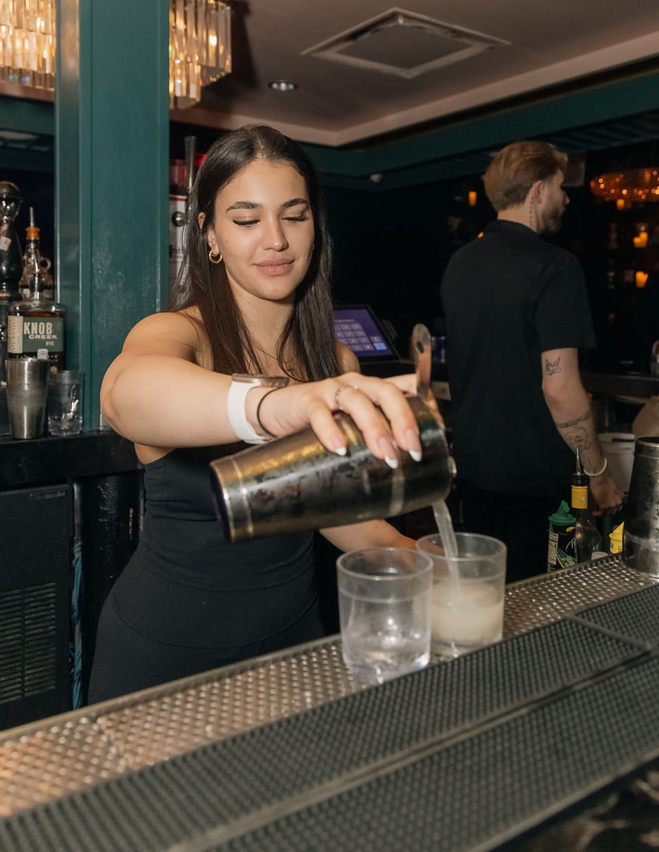 Bartender pouring a cocktail from a shaker