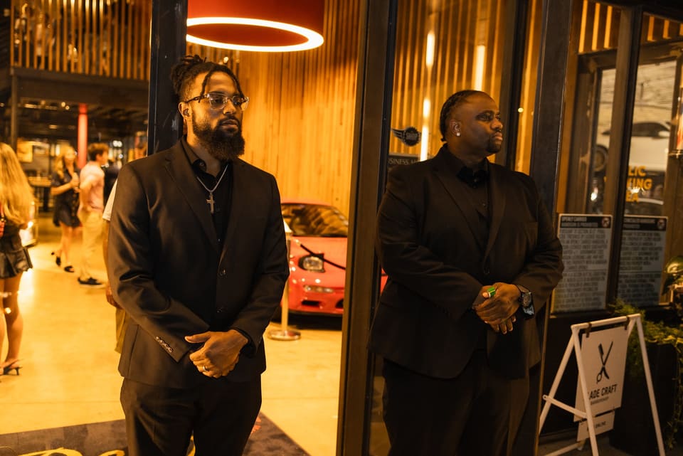 Two Event Experts team members in black at a venue entrance
