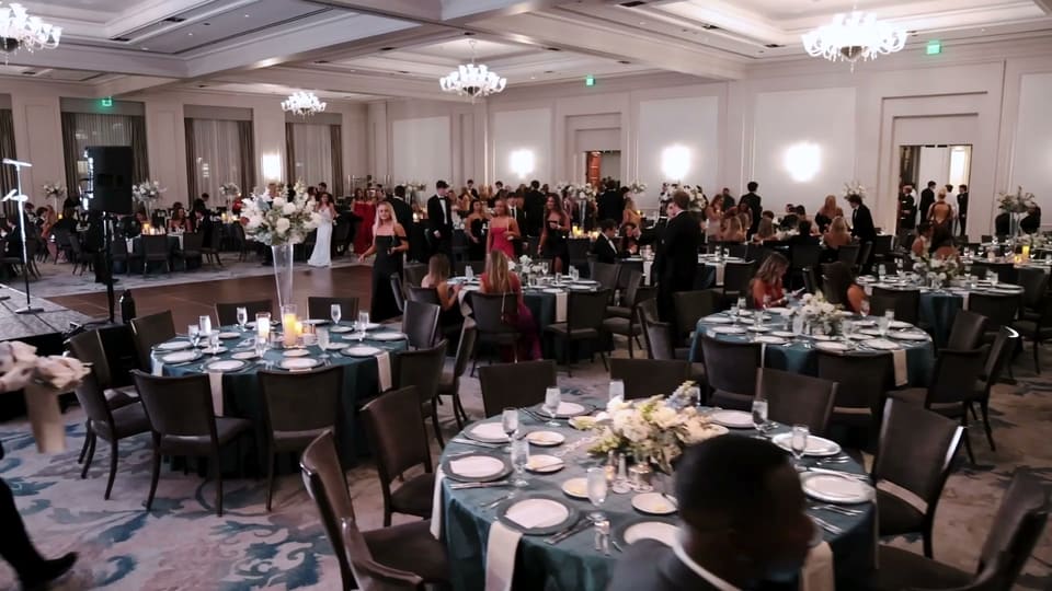 Ballroom set with round tables and centerpieces for a black tie gala